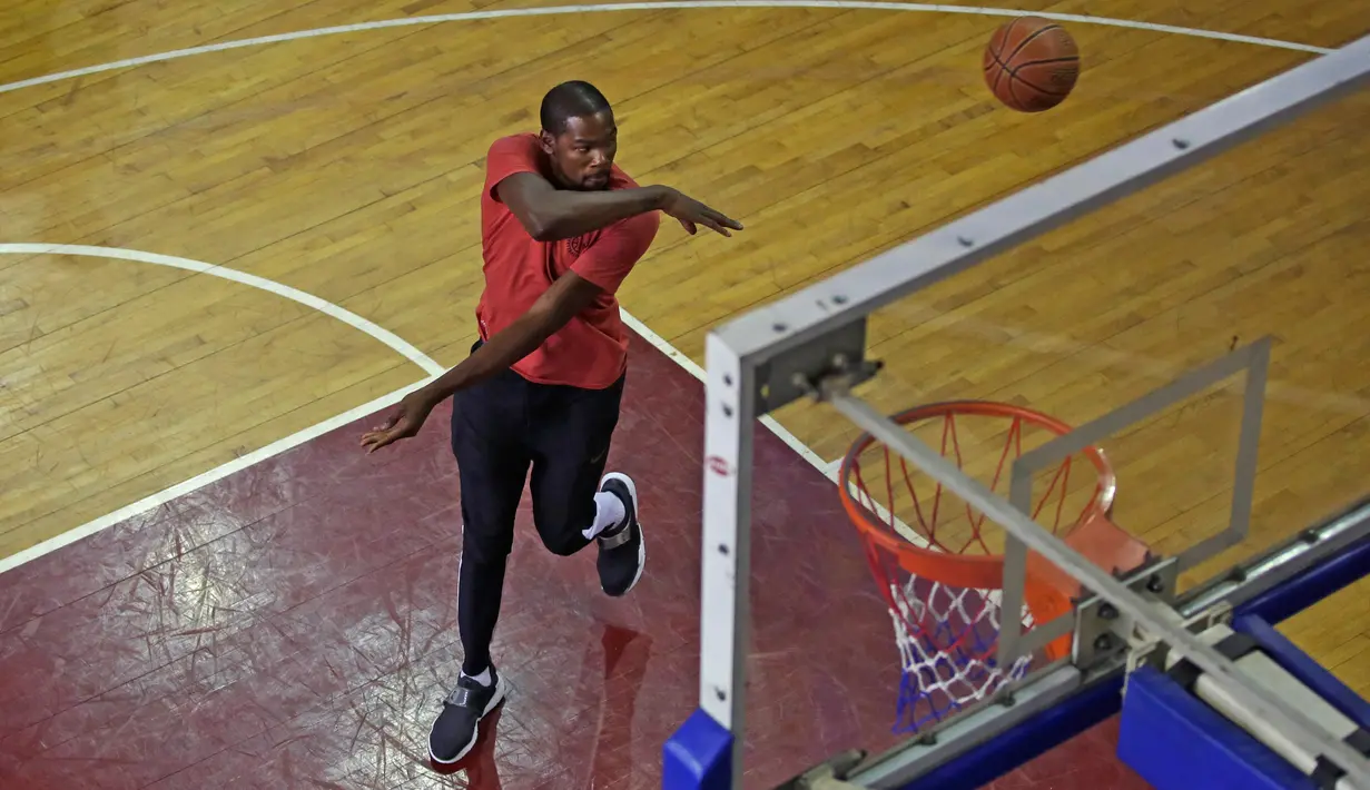 Pemain Golden State Warriors, Kevin Durant menampilkan teknik shooting saat melakukan pelatihan di Greater Noida, New Delhi, 28 Juli 2017. Tak hanya memberi pelatihan, Durant juga membangun dua lapangan basket melalui yayasan amalnya. (AP/Altaf Qadri)