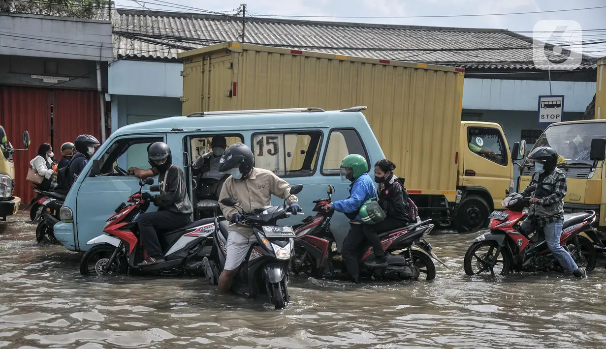 Arus lalu lintas tersendat saat melintasi banjir rob di Jalan Lodan Raya, Ancol, Jakarta, Senin (6/12/2021). Banjir akibat pasang air laut kembali merendam permukiman warga dan menggenangi Jalan Lodan Raya hingga ketinggian 50 cm yang menyebabkan kemacetan lalu lintas. (merdeka.com/Iqbal S Nugroho)