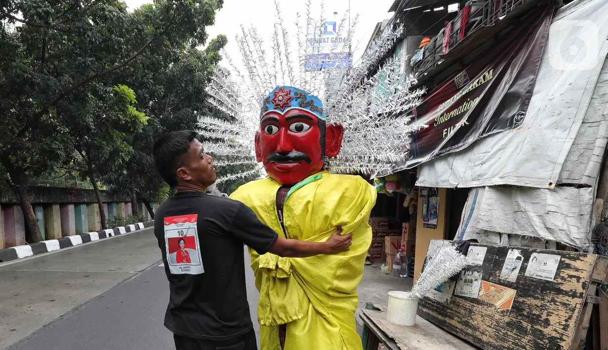 Pemilik tengah memperbaiki ondel-ondel untuk disewakan di kawasan Senen, Jakarta, Jumat (20/9/2024). (Liputan6.com/Angga Yuniar)