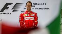 Ekspresi pebalap Ferrari, Sebastian Vettel, setelah menjuarai F1 GP Bahrain, Minggu (16/4/2017). (EPA/SRDJAN SUKI)