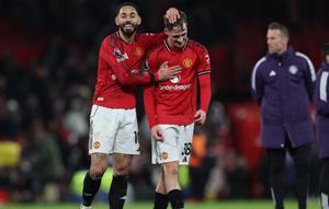 Striker Manchester United asal Brasil bernomor punggung 10, Matheus Cunha (kiri), dan gelandang Manchester United asal Inggris bernomor punggung 38, Jack Fletcher (kanan), merayakan kemenangan di lapangan setelah pertandingan Liga Inggris antara Manchester United dan Newcastle United di Old Trafford, Manchester, barat laut Inggris, Sabtu (27-12-2025) dini hari WIB. Man Utd memenangkan pertandingan dengan skor 1-0. (Darren Staples/AFP)