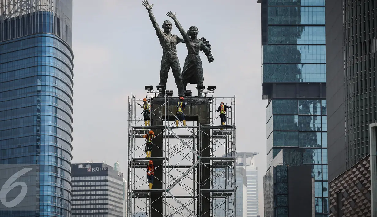Suasana pemasangan kawat baja pada Patung Selamat Datang, Jakarta, Jumat (25/3). Pemasangan tersebut bertujuan untuk menjaga patung dari goncangan ketika bor Antareja melintasi kawasan Bundaran HI. (Liputan6.com/Faizal Fanani) 