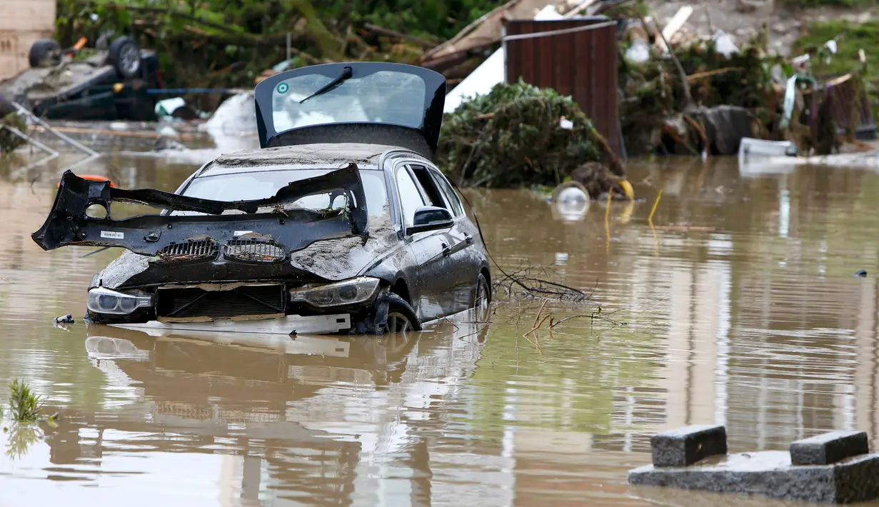 Puing-puing dan sebuah mobil yang rusak akibat banjir di desa Bavarian, Munich , Jerman , 2 Juni 2016. Petugas menemukan 3 wanita  yang tewas diruang bawah tanah rumah yang terendam banjir dan 1 tewas akibat tenggelam di sungai. (REUTERS / Michaela Rehle)