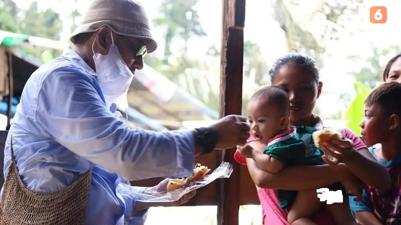 Bupati Bonebol saat memberikan makan kepada balita yang ada di lokasi tambang emas ilegal Suwawa (Arfandi Ibrahim/Liputan6.com)