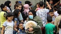 Seorang perempuan meninggalkan toko roti saat orang-orang menunggu giliran, di lingkungan Nabaa, Beirut, Jumat (13/8/2021). Tanpa masker, warga Lebanon berbondong-bondong ke toko roti sebelum fajar untuk membeli roti yang terjangkau ketika pasokan bahan bakar dan obat-obatan terbatas. (ZAYYAT/AFP)