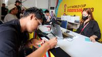 Petugas tengah membantu jurnalis Bola.com, Abdul Aziz mengurus akreditasi peliputan Piala Dunia U-17 2023 yang berlangsung di area sekitar Jakarta International Stadium (JIS), Papanggo, Tanjung Priok, Jakarta Utara, Selasa (07/11/2023). (Bola.com/Bagaskara Lazuardi)