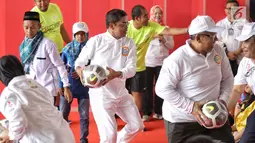 Menteri Sosial (Mensos) Idrus Marham bermain bola dalam acara Gebyar Prestasi Keluarga Sejahtera Indonesia 2018 di Cibubur, Minggu (12/8). Acara diikuti oleh enam ribu peserta anak-anak berprestasi se-Indonesia. (LIputan6.com/Faizal Fanani)
