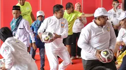 Menteri Sosial (Mensos) Idrus Marham bermain bola dalam acara Gebyar Prestasi Keluarga Sejahtera Indonesia 2018 di Cibubur, Minggu (12/8). Acara diikuti oleh enam ribu peserta anak-anak berprestasi se-Indonesia. (LIputan6.com/Faizal Fanani)