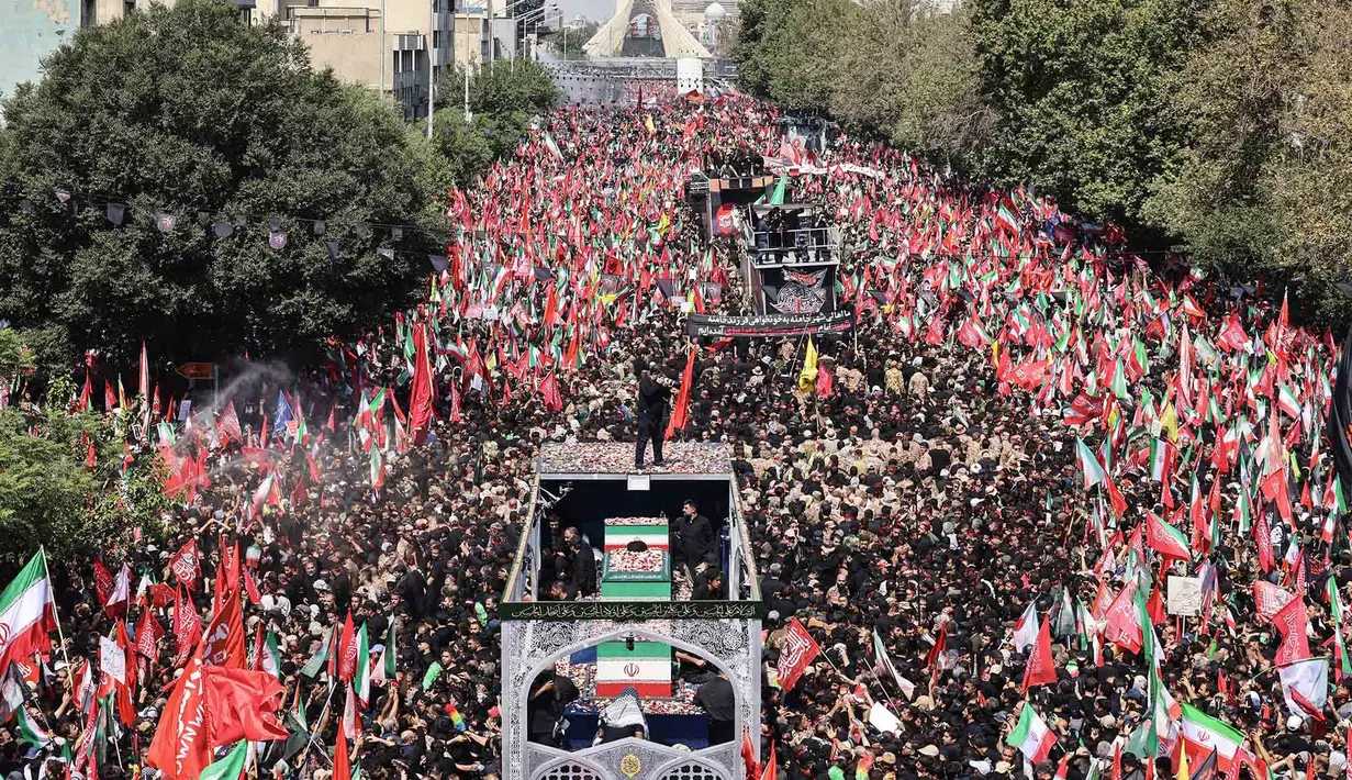 Para pelayat berkumpul di sekitar peti mati pemimpin tertinggi Iran yang terbunuh, Ali Khamenei, dan anggota keluarganya saat prosesi pemakaman menuju Lapangan Azadi di Teheran, Senin, 6 Juli 2026. (AFP/ Atta Kenare)