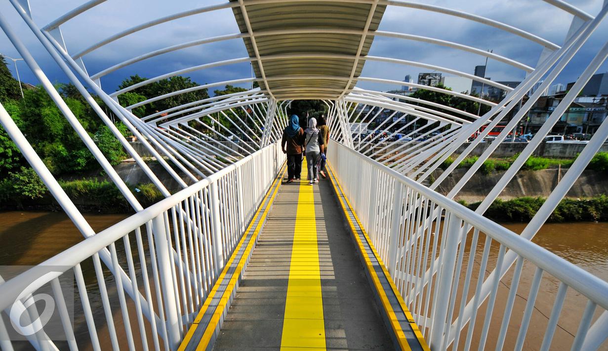 Warga melintas di jembatan penyeberangan orang (JPO) Jayakarta, Manggarai, Jakarta, Rabu (27/4/2016). Warga Manggarai kini dapat melewati sungai Ciliwung melalui JPO Jayakarta. (Liputan6.com/Yoppy Renato)