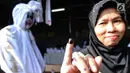 Warga menunjukkan jarinya yang telah dicelup tinta seusai menggunakan hak pilihnya pada Pemilu 2019 di TPS 073, Gunung Balong 1, Lebak Bulus, Jakarta Selatan, Rabu (17/4). TPS 073 ini mengambil tema horor, di mana para petugasnya mengenakan kostum beragam jenis hantu. (merdeka.com/Arie Basuki)