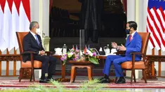 Presiden Indonesia Joko Widodo (kanan) berbincang dengan Perdana Menteri Malaysia Muhyiddin Yassin saat bertemu di Istana Merdeka, Jakarta, Jumat (5/2/2021). Baik Jokowi maupun Muhyiddin Yasin terlihat sama-sama mengenakan masker. (Agus Suparto, Indonesian President Palace via AP)