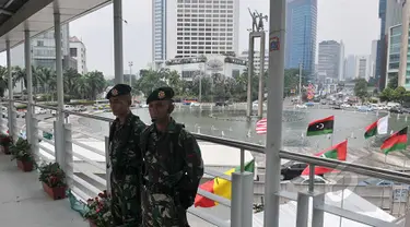 Sejumlah aparat keamanan terlihat berjaga di jembatan penyeberangan orang (JPO) kawasan Bundaran HI, Jakarta, Sabtu (18/4/2015). Sterilisasi dilakukan di tempat-tempat umum yang dilalui peserta Konferensi Asia Afrika (KAA). (Liputan6.com/Johan Tallo)