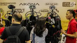 Pengunjung melihat-lihat pakaian diving dalam pameran Deep and Extreme Indonesia (DXI) 2019 di Jakarta, Kamis (4/4). DXI 2019 mengusung tema bersih, nyaman, aman dan nyaman untuk berwisata. (Liputan6.com/Faizal Fanani)