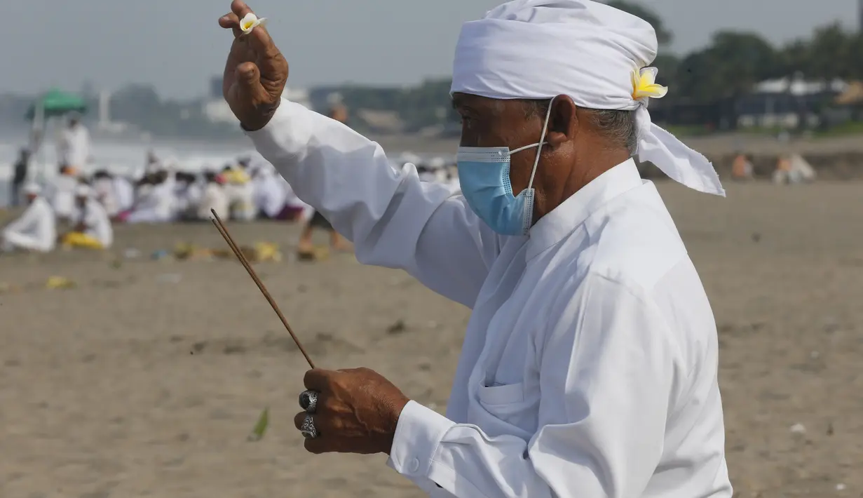Seorang pria berdoa selama ritual Melasti di Bali, Senin (28/2/2022). Ritual yang dilakukan menjelang Hari Raya Nyepi umat Hindu ini diadakan untuk menyucikan alam semesta dari pengaruh buruk, perbuatan dan pikiran buruk. (AP Photo/Firdia Lisnawati)