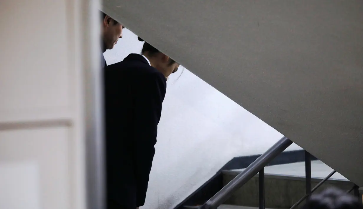 Penyanyi K-pop, Jung Joon Young tiba untuk mengikuti persidangan di kantor pengadilan Seoul, Kamis, (21/3). Tersangka penyebaran video seks ilegal itu diadili terkait surat perintah penangkapan yang diajukan untuknya. (REUTERS/Kim Hong-Ji)