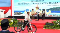 Warga membawa hadiah sepeda yang diberikan oleh Presiden Jokowi saat membagikan sertifikat di GOR Way Handak, Kalianda, Lampung Selatan, Lampung, Minggu (21/1). (Liputan6.com/Pool/Laily Rachev-Biro Pers Setpres)