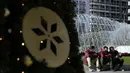 Pria yang memakai masker duduk di depan air mancur di Omonia square, Athena, Kamis (23/12/2021). Yunani membatalkan konser Natal dan acara lainnya sebagai bagian dari pembatasan baru yang mencakup mandat penggunaan masker di luar ruangan dan semua area publik. (AP Photo/Thanassis Stavrakis)