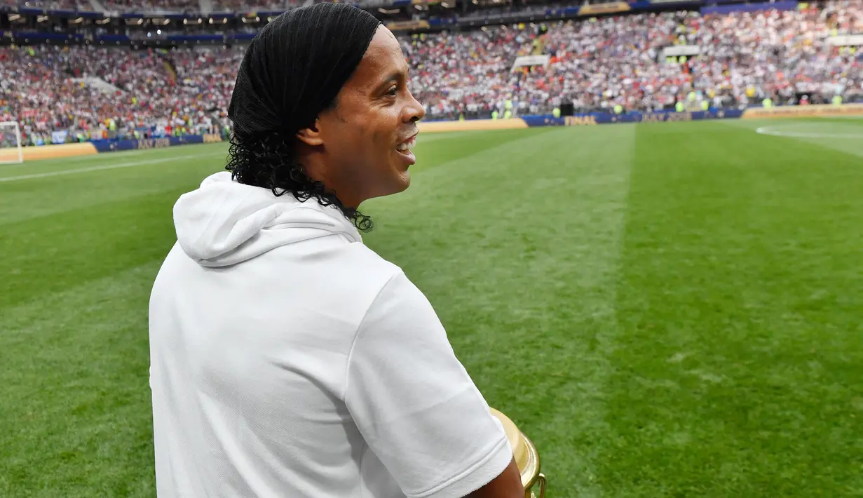 Legenda sepakbola Brasil, Ronaldinho menabuh jenis musik gendang, bongo pada seremonial final Piala Dunia 2018 antara Prancis vs Kroasia di Stadion Luzhniki, Minggu (15/7). Kehadiran Ronaldinho membuat suporter antusias. (AP/Martin Meissner)