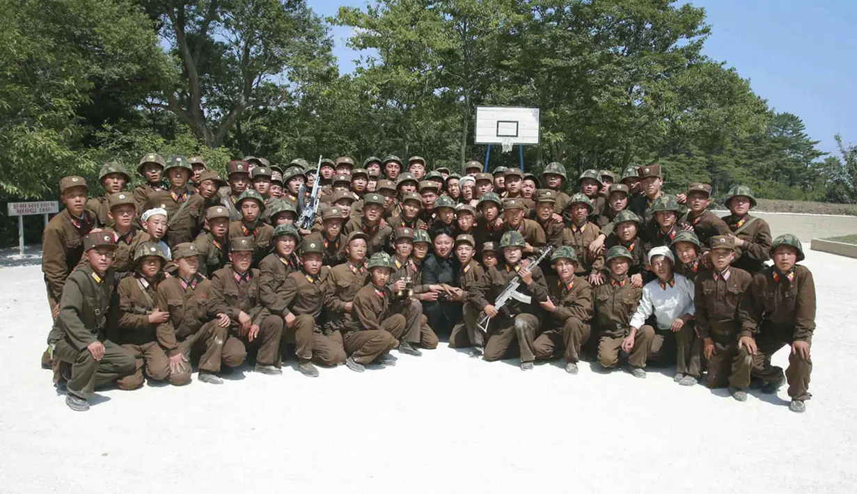 Pemimpin Korea Utara, Kim Jong Un (tengah), berpose bersama anggota polisi sipil di bawah KPA Satuan 171 yang berjaga di garis terdepan, (15/7/2014). (REUTERS/KCNA)