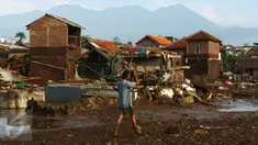 Warga mengangkat sepeda miliknya pasca banjir bandang yang menerjang Kampung Cimacan, Kecamatan Tarogong Kidul, Kabupaten Garut, Kamis (22/9). Berdasarkan data sementara Basarnas Jabar korban tewas 23 orang dan belasan hilang. (Liputan6.com/Johan Tallo)