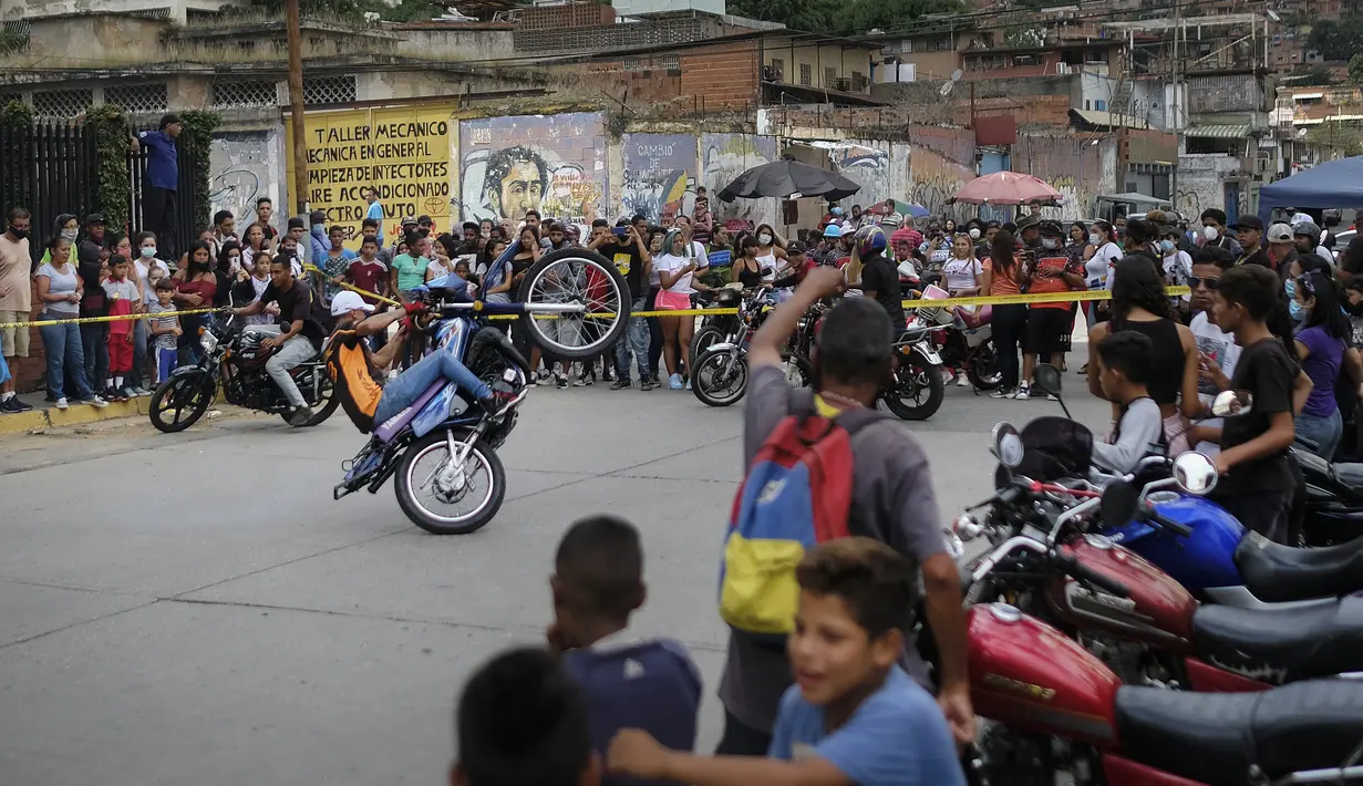 Pengendara sepeda motor tampil di atas sepeda motor mereka selama pameran di lingkungan El Valle Caracas, Venezuela, Sabtu (31/7/2021). (AP Photo/Ariana Cubillos)