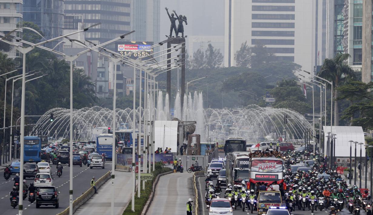 Pemain dan ofisial Timnas Indonesia U-22 menaiki bus tingkat saat konvoi menuju Istana Negara Jakarta, Kamis (28/2). Pawai tersebut untuk merayakan keberhasilan skuat Garuda Muda menjuarai Piala AFF U-22 di Kamboja. (Bola.com/M Iqbal Ichsan)