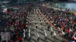Warga memadati pinggiran jalan di kawasan Bundaran HI saat parade bendera digelar, Jakarta, Minggu (30/10). Parade ini merupakan rangkaian arak-arakan parade Bendera Menjelang Sidang Umum Interpol Ke-85. (Liputan6.com/Johan Tallo)