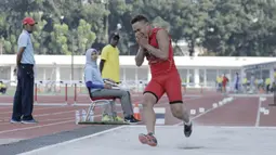 Atlet lompat jauh DKI Jakarta, Noval, tertawa usai melakukan lompatan saat kejurnas atletik di Stadion Madya, Senayan, Jakarta, Rabu (9/5/2018). Noval berhasil menjadi juara dengan loncatan sejauh 7,14 Meter. (Bola.com/M Iqbal Ichsan)