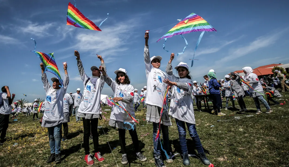 Suasana ketika anak-anak sekolah Palestina menerbangkan layangan dalam aksi solidaritas peringatan tujuh tahun gempa dan tsunami Jepang di Gaza, Selasa (13/3). (SAID KHATIB/AFP)