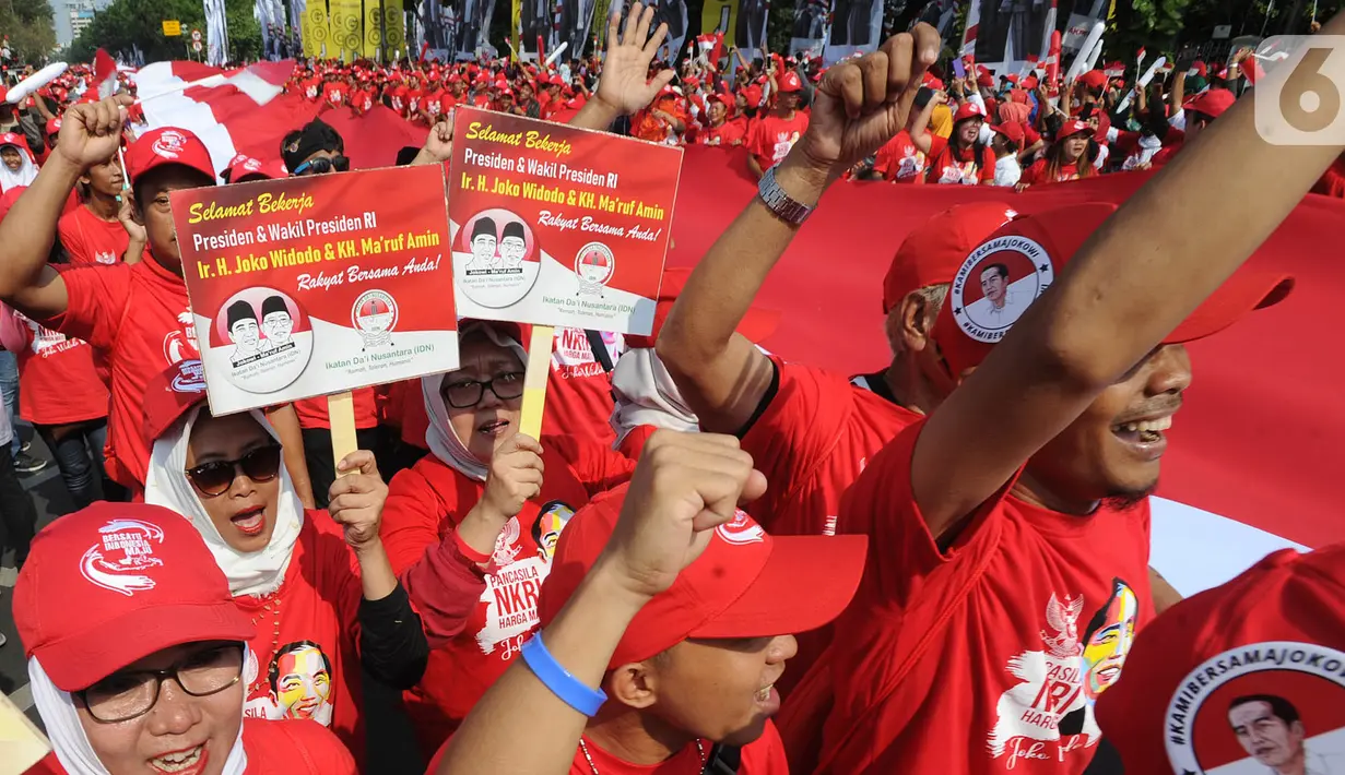 Relawan Jokowi-Ma'ruf Amin membawa bendera raksasa sepanjang sekitar 200 meter saat menyambut pelantikan Presiden-Wapres terpilih periode 2019-2024 di sekitar Patung Kuda, Jakarta, Minggu (20/10/2019). (merdeka.com/Arie Basuki)