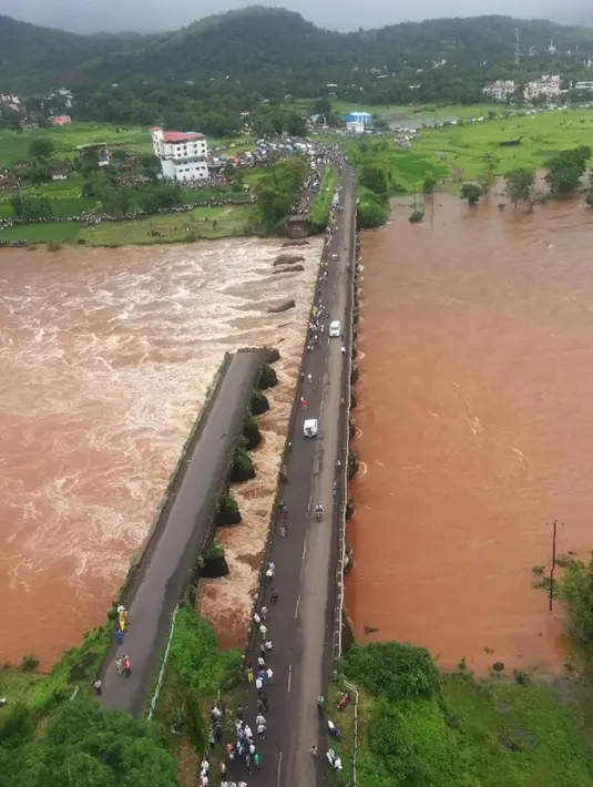 Kondisi jembatan jalan raya yang runtuh akibat derasnya aliran sungai Savitri yang sedang meluap di barat India, Rabu (3/8). Jembatan jalan raya tersebut menghubungkan kota Mumbai dengan negara bagian Goa. (AFP)