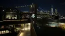 Gambar korban diproyeksikan pada Jembatan Brooklyn saat Hari Peringatan COVID-19 di Brooklyn, New York, Amerika Serikat, 14 Maret 2021. Acara penghormatan yang digelar kepada 30.258 kematian di New York, terjadi setelah satu tahun berlalu dimulainya pandemi di AS. (Kena Betancur/AFP)