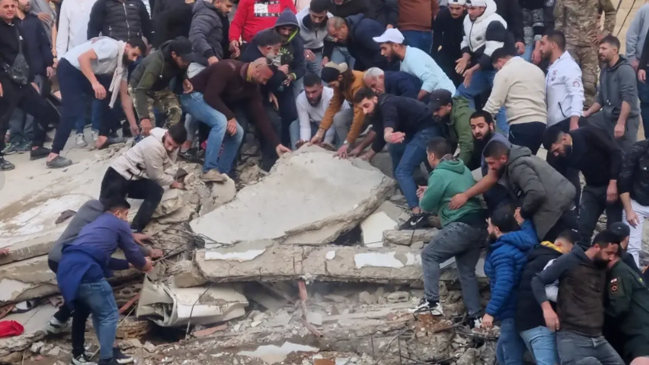 Petugas penyelamat dan warga mencari korban selamat di reruntuhan bangunan yang runtuh di kota Tripoli, Lebanon utara, Minggu, 8 Februari 2026. (Dok. AP)
