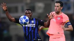 Gelandang Inter Milan, Kwadwo Asamoah, berebut bola dengan gelandang Barcelona, Sergio Busquets, pada laga Liga Champions di Stadion San Siro, Milan, Selasa (6/11). Kedua klub bermain imbang 1-1. (AFP/Marco Bertorello)