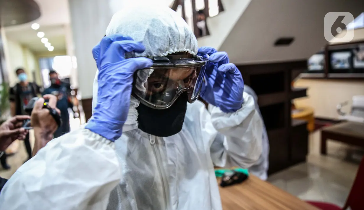 Petugas bersiap melakukan penyemprotan cairan disinfektan di Gedung KPU Pusat, Jakarta, Selasa (21/7/20).  Penyemprotan dilakukan setelah seorang pegawai Komisi Pemilihan Umum (KPU) RI terpapar virus Covid-19. (Liputan6.com/Faizal Fanani)