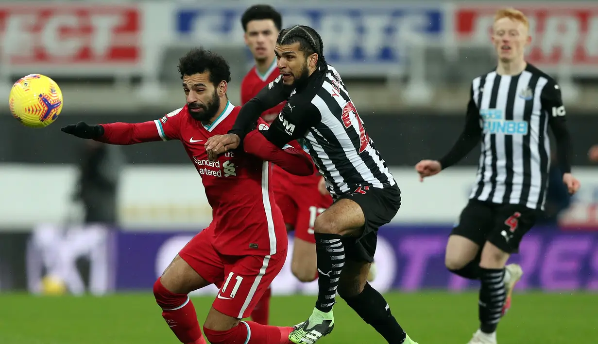 Gelandang Liverpool, Mohamed Salah (kiri) berebut bola dengan bek Newcastle United, DeAndre Yedlin dalam laga lanjutan Liga Inggris 2020/21 pekan ke-16 di St James' Park, Rabu (30/12/2020). Liverpool bermain imbang 0-0 dengan Newcastle United. (AFP/Scott Heppell/Pool)
