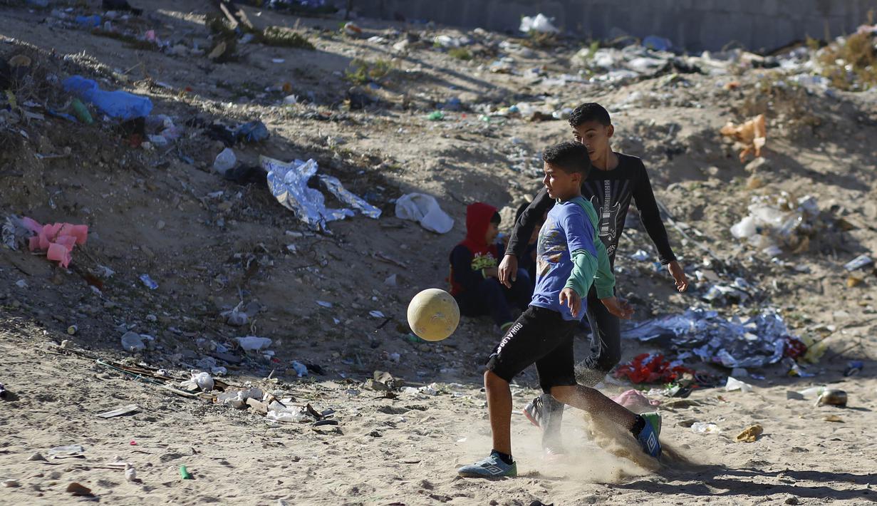Sejumlah anak Palestina bermain sepak bola di kawasan Gaza, Jumat (3/11/2017). Sepak bola tidak hanya menjadi olahraga favorit, tapi juga sebagai salah satu cara bagi warga untuk mengurangi ketegangan akibat peperangan. (AFP/Mohammed Abed)