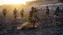 Para pria bermain sepak bola di pantai di tengah gelombang panas musim panas di Carilo, provinsi Buenos Aires, Argentina (14/1/2022). Argentina menghadapi gelombang panas paling ekstrem dalam sejarah dengan suhu yang melonjak di atas 40 derajat celcius. (AP Photo/Rodrigo Abd)