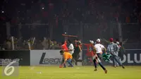 Suporter Persija melempari petugas kepolisian saat terlibat kericuhan pada laga lanjutan Torabika Soccer Championship presented by IM3 Ooredoo antara Persija melawan Sriwijaya FC diStadion GBK Jakarta, Jumat (24/6). (Liputan6.com/Helmi Fithriansyah)