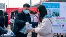 Seorang staf memeriksa suhu tubuh calon peserta ujian pegawai negeri sipil (PNS) nasional China di sebuah universitas di Nanjing, Provinsi Jiangsu, China pada 29 November 2020. Ujian PNS nasional China untuk angkatan 2021 diadakan di seluruh penjuru negeri itu. (Xinhua/Du Yi)
