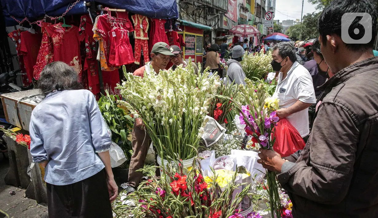 Penjual melayani pembeli bunga hias di Pasar Petak Sembilan, Glodok, Jakarta, Senin (31/1/2022). Jelang tahun baru Imlek 2573 sejumlah bunga seperti sedap malam, aster, mawar dan lainnya mulai banyak dicari warga Tionghoa untuk sembahyang. (Liputan6.com/Faizal Fanani)