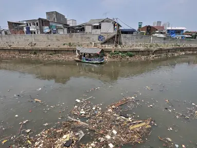 Jasa perahu getek saat mengantar warga menyeberangi Kali Ciliwung yang penuh sampah, Jakarta, Selasa (4/9). Kementerian Lingkungan Hidup dan Kehutanan mencatat sekitar 7.000 ton sampah dibuang ke Kali Ciliwung setiap harinya. (Merdeka.com/Iqbal Nugroho)