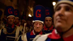 Sejumlah pria mengenakan seragam sambil memukul drum saat perayaan La Tamborrada di kota Basque San Sebastian, Spanyol (20/1). Mereka berseragam pakaian militer dan juru masak menabuh snar drum keliling kota. (AP Photo / Alvaro Barrientos)