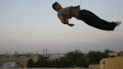 Seorang Traceur (sebutan untuk penggiat Parkour) sedang melakukan aksi Parkour berupa terjun bebas, Irak, Rabu (14/05/2014) (AFP PHOTO/HAIDER HAMDANI).