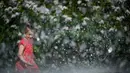 Seorang gadis mendinginkan diri di air mancur saat musim semi yang panas di Moskow, Rusia, Selasa (18/5/2021). Suhu di Moskow telah mencapai 31 derajat Celcius. (Natalia KOLESNIKOVA/AFP)