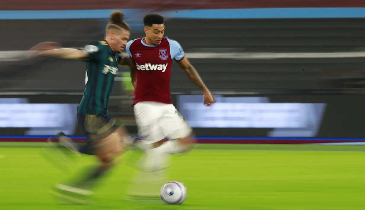 Pemain West Ham United Jesse Lingard (kanan) memperebutkan bola dengan pemain Leeds United Kalvin Phillips pada pertandingan Liga Inggris di Stadion London, London, Inggris, Senin (8/3/2021). West Ham United menang 2-0. (Ian Walton, Pool)