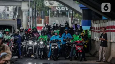 Pengendara sepeda motor memenuhi ruas jalan ketika berteduh di kolong Fly Over Cawang, Jakarta, Selasa (17/12/2019). Perilaku tersebut selain menimbulkan ketidaknyamanan pengguna jalan lainnya, juga memicu kemacetan. (Liputan6.com/Faizal Fanani)