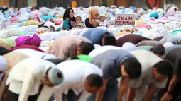 Dua orang ibu menggendong anak mereka saat umat muslim melaksanakan salat Idul Adha 1439 H di Monumen Perjuangan Jatinegara, Jakarta Timur, Rabu (22/8). (Liputan6.com/JohanTallo)