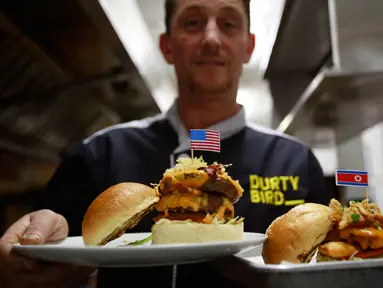 Pemilik restoran, Collin Kelly memperlihatkan burger "Durty Donald" dan "Kim Jong Yum"  yang baru dibuat di Hanoi, Vietnam, 24 Februari 2019. Restoran ini membuat 2 jenis burger khusus untuk menyambut kedatangan Kim Jong-un dan Donald Trump. (AP/Hau Dinh)